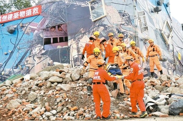 防災演習模擬出強震造成房屋嚴重坍塌，救難人員以擔架抬出在瓦礫堆中的生還者。 記者吳佩旻／攝影