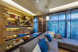 客廳的沙發部分使用的為深灰色3＋1的款式，也是時下主流大家都會想購入的可坐又可躺的款式。設計師將可躺的方向側向對外落地窗，這裡就可形成一個小小的閱讀或發呆空間。