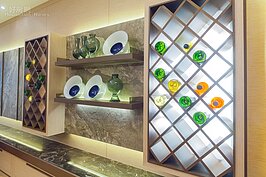 美味的餐點需要美酒來點綴。設計師在餐廳旁牆面上設計了兩組以木頭交錯形成的開放式酒櫃；搭配了背投射燈，形成鮮明的藝術風情。