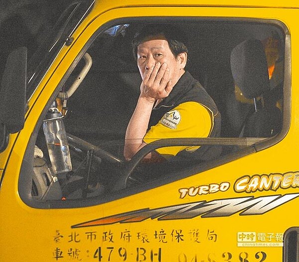 圖為環保局清潔人員定時定點為民眾收取家用垃圾。（季志翔攝）