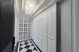 美式都會風格的兩項重要元素，分別為強烈的空間感與立體感。設計師在玄關處就充分表現這兩項元素。包括地面採黑白菱形拼接的大理石地板；鞋櫃部分的門板利用木條做出深淺框，搭配白色的油漆與水晶吊燈，讓人一走入如同到了美國紐約住家的感覺。

這樣的設計感念在這間實品屋內處處可見。