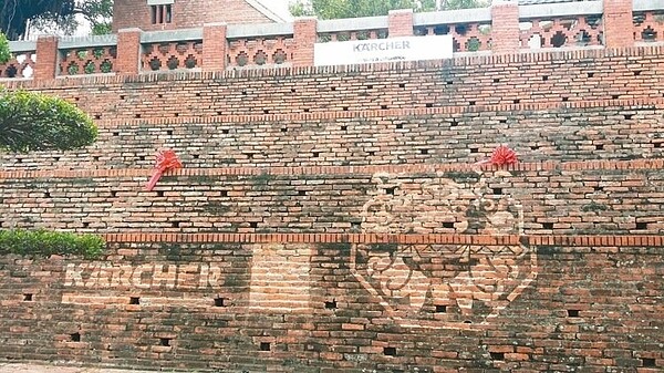 四百年歷史的台南安平古堡第一次「洗臉」,清洗團隊在紅磚上留下安平劍獅圖騰,凸顯紅磚清洗前後不同色澤。 記者修瑞瑩/攝影