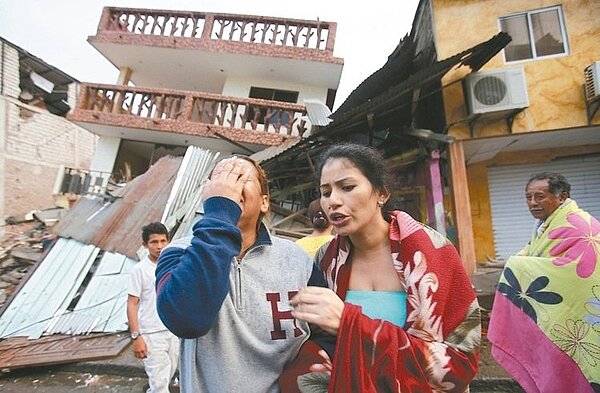 厄瓜多佩德納萊斯鎮一名女子十七日在震毀的家園旁掩面痛哭。 美聯社
