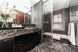 主臥室所搭配的衛浴設備中，地面、浴缸以及洗手台都採同質料、同紋路的高級石材，這裡的感覺則與客廳、主臥室所營造的中式古典風格有著明顯的落差。若是想要讓風格延續一路到底，不妨可利用防水的木材打造出更為溫暖的浴室風格。