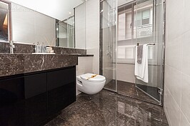 共用的浴室與主臥浴室一樣，使用高級石材進行裝潢。但並沒有浴缸，僅有乾濕分離的淋浴間。