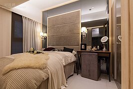 主臥室可用的室內面積也不大，因此在床頭面周邊利用墨色玻璃來求得更大的空間感表現。當然，若還有更多的收納空間需求，可在梳妝台那面牆上多做一組櫥櫃。

或者梳妝台寬度縮小一點，將床組移到中間，然後床尾處靠牆另外做一面櫥櫃也是可行的辦法。