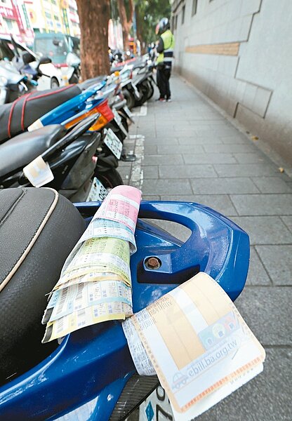 北市許多路段機車停車收費，希望增加停車格使用的更換率。部分騎士對停車繳費單似視若無睹，任憑釘掛在車後把手日曬雨淋，「使用者付費」在他們的眼中，似乎只是口號。 圖／杜建重