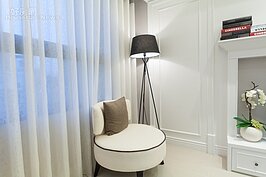 大空間的客廳靠窗角落擺放了落地燈與單人小沙發，形成另一個人天地。一杯香淳咖啡與一本好書，就可在此消磨一下午。若預算許可下，此區可做一個墊高略與窗下沿同高的空間，靠窗席地而坐也是不錯的感覺。