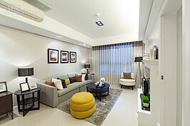 客廳沙發越大，所佔用的空間越多，相對的也可視覺上更顯得擁擠。可是閨密來聚會，總要有個地方可以坐下聊天。設計師在主沙發部分僅放置一組三人沙發，並將沙發茶几縮小一半尺寸，剩下空間擺放可隨時調整位置的黃色沙發，增加了調度靈活性，黃色沙發部分也可讓整體空間增加色彩感而不會顯得太單調。