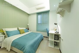 另外一間臥室較為麻煩的是床頭頂上有樑柱，換個角度變成床尾朝門床頭朝窗，在風水上都不是好的擺放方式。解決辦法不外乎做成吊櫃或者是床頭增加床頭櫃以避開樑柱直接壓頂的視覺壓力，但會犧牲掉床尾空間。其實只要透過如照片中這樣簡單的方式，木板直接往上延伸，到樑柱處形成一個曲線就可改善。