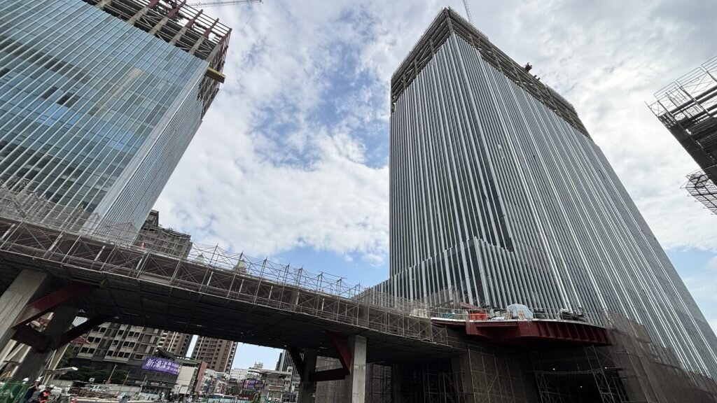 第二行政中心大樓（右）外牆帷幕工程已接近完成，公共區域也正在裝修，朝年底啟用目標邁進。圖／新北市政府