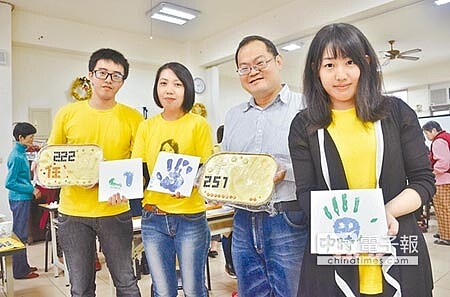 大溪區仁義里長黃禎(右二)教導民眾,透過五顏六色的顏料將民眾手印轉印至磁磚上。(康鴻志攝)