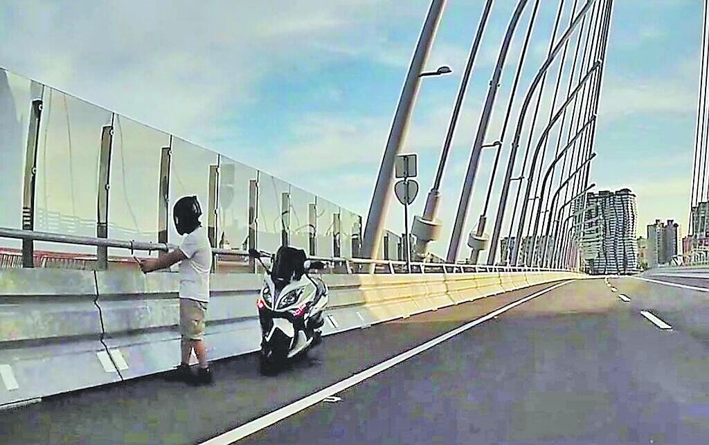 淡江大橋汽車道17日有黃牌大型重機騎士違規停在路肩自拍，淡水、蘆洲警分局鎖定資料逕行開罰，該騎士將收到2張罰單。圖／民眾提供