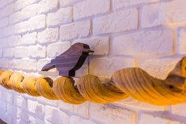 草山客房中利用天然捲曲的樹枝當成床頭裝飾，簡單的木頭鳥就棲身在上，簡單的設計卻帶出了客房的特色。