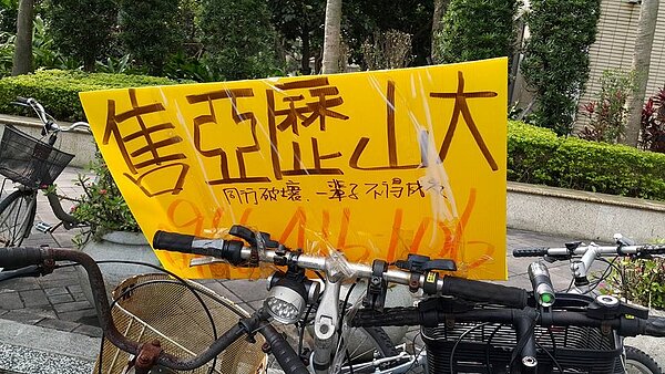 信義區捷運象山站附近的房仲廣告看板上,出現「同行破壞,一輩子不得成交」的詛咒。(好房網News記者陳佑婷/攝影)