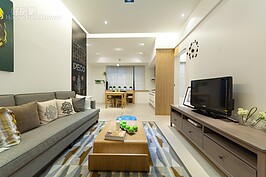 略為長方形的客廳看似難以變化，其實用點心思還是可以營造出令人舒服的起居空間。例如以三座位組的沙發搭配挑高的天花板；電視櫃採購市售系統傢俱，簡單的幾何線條與牆面佈置，可營造出俐落的空間感。
當然，若覺得收納空間不夠，在電視櫃部分可使用凹字型的產品，電視上方再加上兩組置物平台，然後沙發找尋坐墊下也有收納空間的產品，可讓收納空間再增加不少。