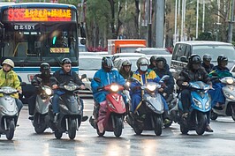 下雨又吹著冷風，為了討生活，機車族穿著厚重的外套加上雨衣，能讓自己溫暖多少就溫暖多少。（好房網記者張聖奕／攝影）