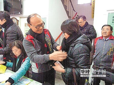 公道伯劉興榮(中)幫弱勢民眾繫圍巾抗寒。(王文吉攝)