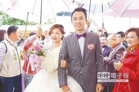 締良緣嘉義市民集團結婚,新人在傘海下,牽手走紅毯,接受眾人祝福。(廖素慧攝)