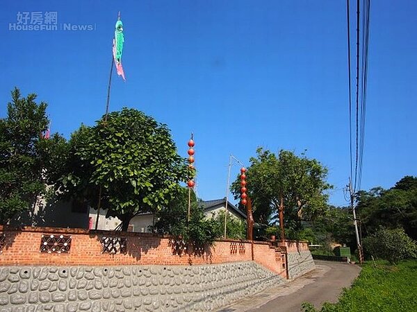 2. 三合院外以石砌牆垣,懸掛旌旗。