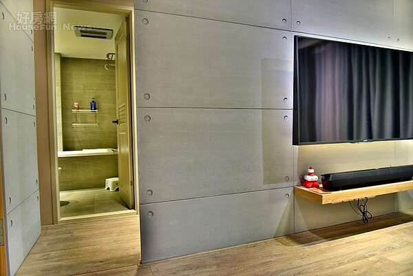 5.仿清水模電視牆左方的主臥入口採隱藏門設計,除能達到牆面延伸效果,也可維持視覺上整體感。