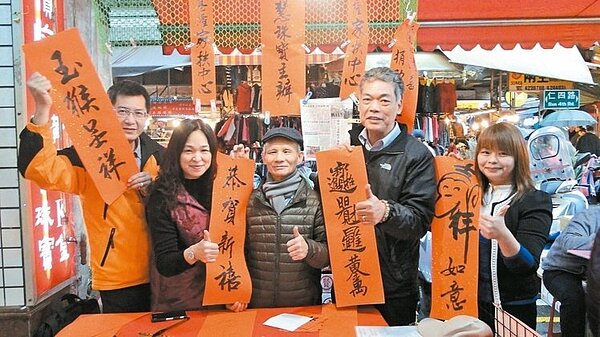 青田書會創會會長張明萊(中)與采慧金飾老闆娘翁采慧(左二)合力辦春聯義賣,一連7天,所得將全數捐助家扶弱勢小朋友。 記者游明煌/攝影