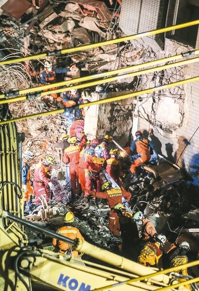 F棟14樓探測出生命跡象，搜救人員入夜後在東側持續以人力挖開土石搜救。 記者黃威彬／攝影