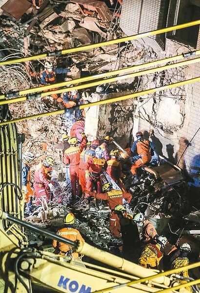 F棟14樓探測出生命跡象,搜救人員入夜後在東側持續以人力挖開土石搜救。 記者黃威彬/攝影