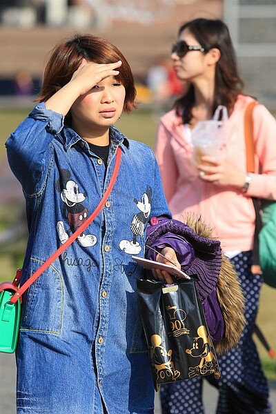 春節假期即將結束,台北昨天高溫上看28度,民眾出遊時熱到脫下外套。 記者林伯東/攝影