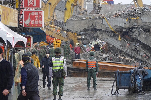 昨天台南市災區一度下起滂沱陣雨,救難人員冒雨繼續搜救。 記者鄭維真/攝影