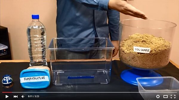 網友以泥土樣本、建築物模型為例，模擬土壤液化時產生的現象。（翻攝自Youtube）