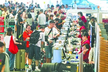 桃園國際機場公司證實,「機場服務費」將採兩階段調整。圖為桃機出境旅客在航空公司櫃台辦理登機報到手續。(陳麒全攝)