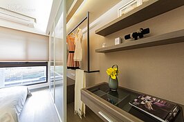 主臥室的衣櫥為現場木作所作成，搭配黑色方形鋼管當作掛架使用，拉門部分則是彩透明玻璃，目的是盡量增加室內空間感。