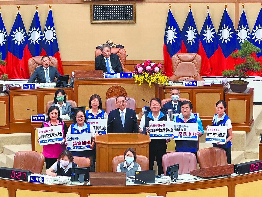 新北市長侯友宜（中）27日在新北市議會宣布，因應新北市國中小免費營養午餐上路，教育局斥資4億預算，包括提供導師與午餐承辦人每月1500元午餐指導費、提高國小教師員額為每班教師比1.75人、國中小導師各減授1節課。（柯毓庭攝）