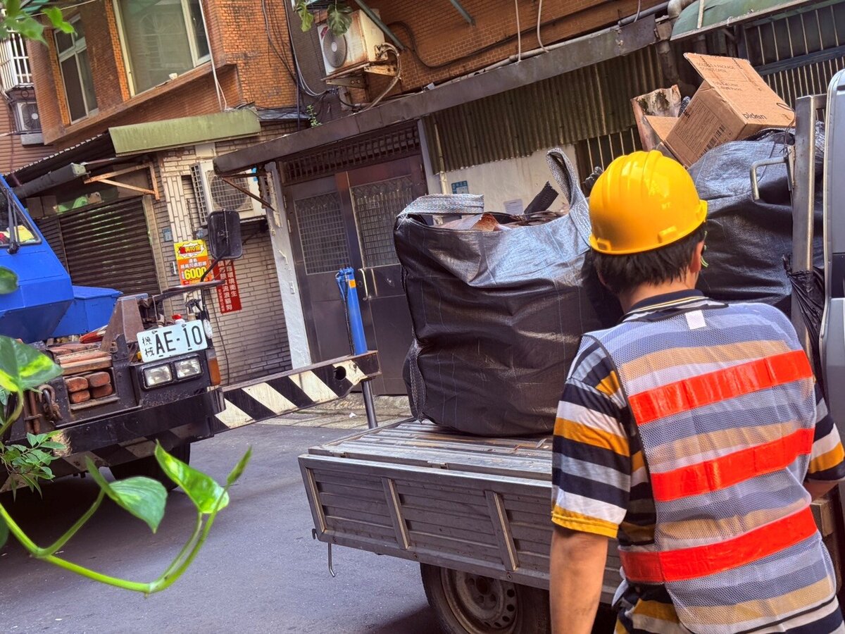 新莊區中正路377巷1弄2號廢棄物清理作業，採以太空包集中裝載後，由吊車吊運至地面，再以小貨車載運至巷口集運清運。圖／新莊區公所提供