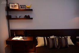 木頭書桌與木架放在床頭旁邊，一點都不會讓人有辦公桌的沉重感