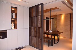 玄關與餐桌中間以木製柵欄隔開，除了融入整體設計外，有隱蔽效果但不致於封閉