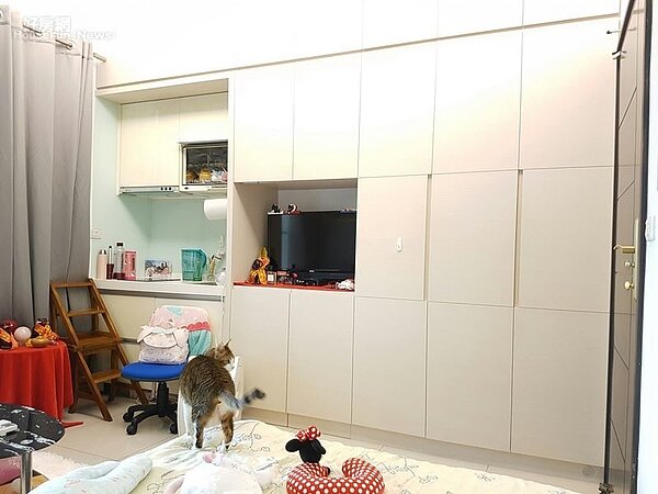 4.雙人床與沙發正前方有一大面系統收納櫃,一旁還有系統廚具流理台。