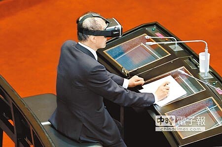 虛擬體驗 行政院長林全3日到立法院備詢,第一次上台答詢即遇到立委要求戴上VR(虛擬實境)裝置,林全戴上裝置後不得不坐在椅子上答詢。(姚志平攝)