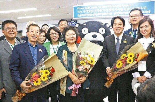 高雄市長陳菊（前左二）、台南市長賴清德（前左三）等人昨天抵達日本熊本阿蘇機場，和新駐日代表謝長廷（前左一）會合，受到熊本吉祥物「熊本熊」熱烈歡迎。 圖／高雄市新聞局提供