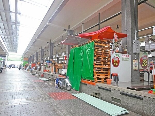 一場雷陣雨… 嘉義市新建果菜市場鬧水患,承銷商拿紙箱蓋在水果上或撐傘擋住。 記者魯永明/攝影