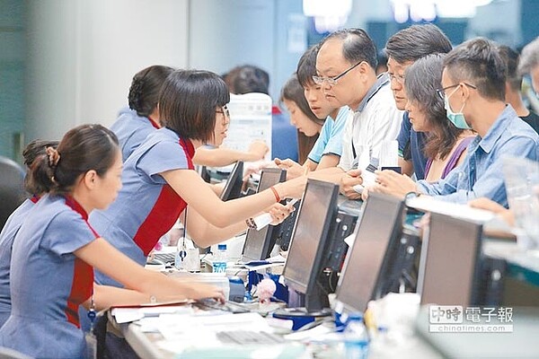 旅客圍著華航櫃台詢問航班資訊，地勤人員忙著協助轉機或更改行程。（陳麒全攝）