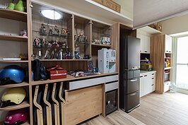 客廳另一側整面牆都是木作櫃，放著夫妻倆喜歡的動漫人物公仔，以及日本旅遊帶回來的紀念品。