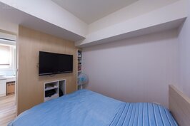 主臥房很簡單，沒有多餘的傢俱與設計。半開放式的木質電視牆後面就是更衣室與主臥房浴室。