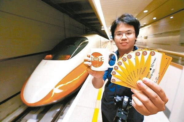 三鐵共構的南港站今天開出首班高鐵列車,高鐵也送出限量馬克杯給搭乘旅客,一名劉姓鐵道迷(見圖),開心拿著11張首班車票與馬克杯,與高鐵列車合影留念。 記者許正宏/攝影