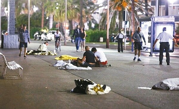 法國國慶日,巴黎的煙火照亮艾菲爾鐵塔,但尼斯發生慘劇,案發後,部分罹難者陳屍街頭,法國尼斯警方和醫護人員在大街上照顧恐攻事件的傷者。 圖/路透