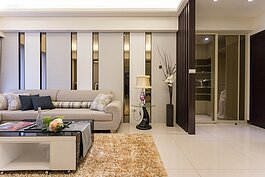 面對客廳沙發後牆壁還可看到左邊有一塊小空間。基本上這裡大都會作鞋櫃或簡易收納櫃使用。設計師則是將此空間做了玻璃滑門區隔，注重隱私的人可以使用霧面玻璃。