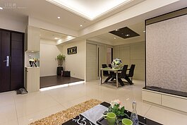 由客廳沙發看餐廳與休憩區的樣子。照片中可看到大門右邊有一個小的鞋櫃。為了閃避客廳電燈開關，因此鞋櫃中間置空設計，這個位子可擺花瓶也可擺放鑰匙等小物。