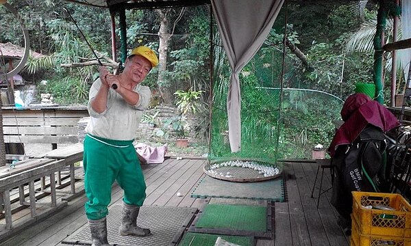 5. 吳富德在農園廣場簡易高爾夫練習區自娛。