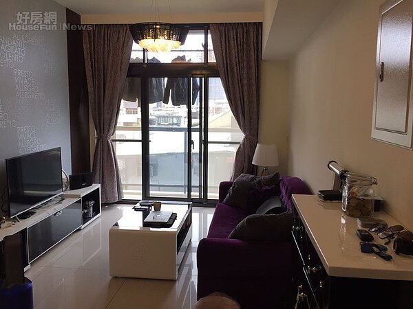 2.客廳旁有陽台,透光性很好,搭配命理師房東選擇的紫色沙發及黑白色系的電視櫃,大色塊增加時尚感。